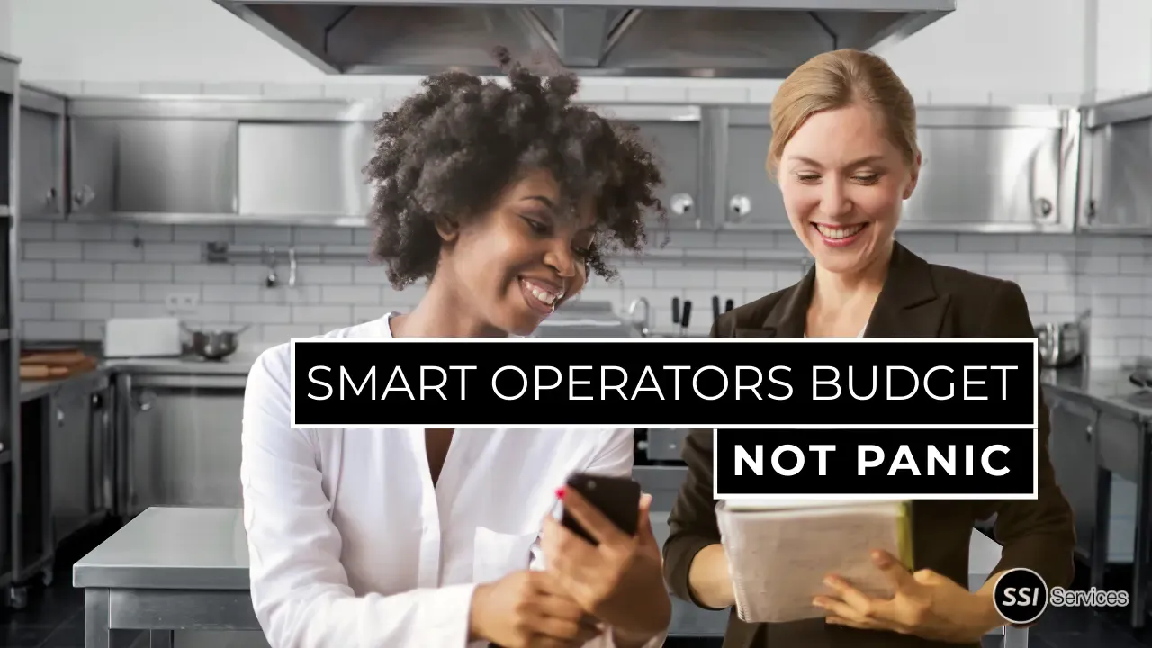 Restaurant operators reviewing maintenance and equipment budgeting data in a commercial kitchen to prevent emergency repairs and downtime.